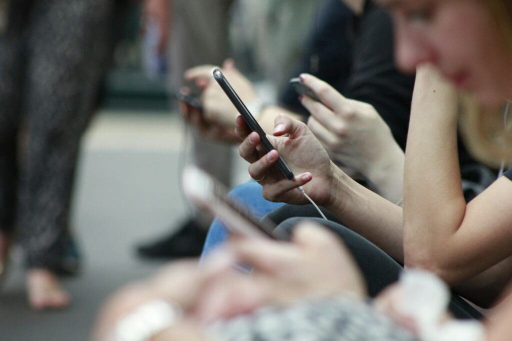 A photo of people's hands holding phones and endless scrolling in a train