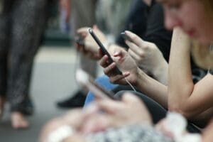 A photo of people's hands holding phones and endless scrolling in a train