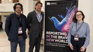 Hassan (left), Wouter (center) and Giovana (right) post in front of a standing banner at the World Press Freedom Day event in Brussels