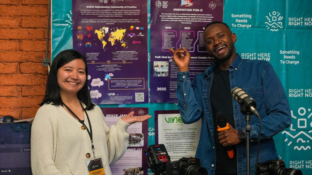 In this photo, Marah (left) and Sam (right) pose in front of several posters. The posters share information about RHRN, a programme where RNW Media is one of the consortium partners.